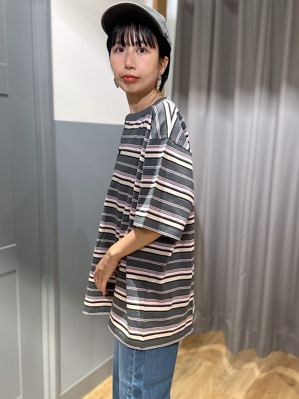 グレー系のTシャツ/カットソー、ブルー系のデニムパンツ、ベージュ系のトートバッグを着用したレディースの夏コーディネートの5枚目の写真