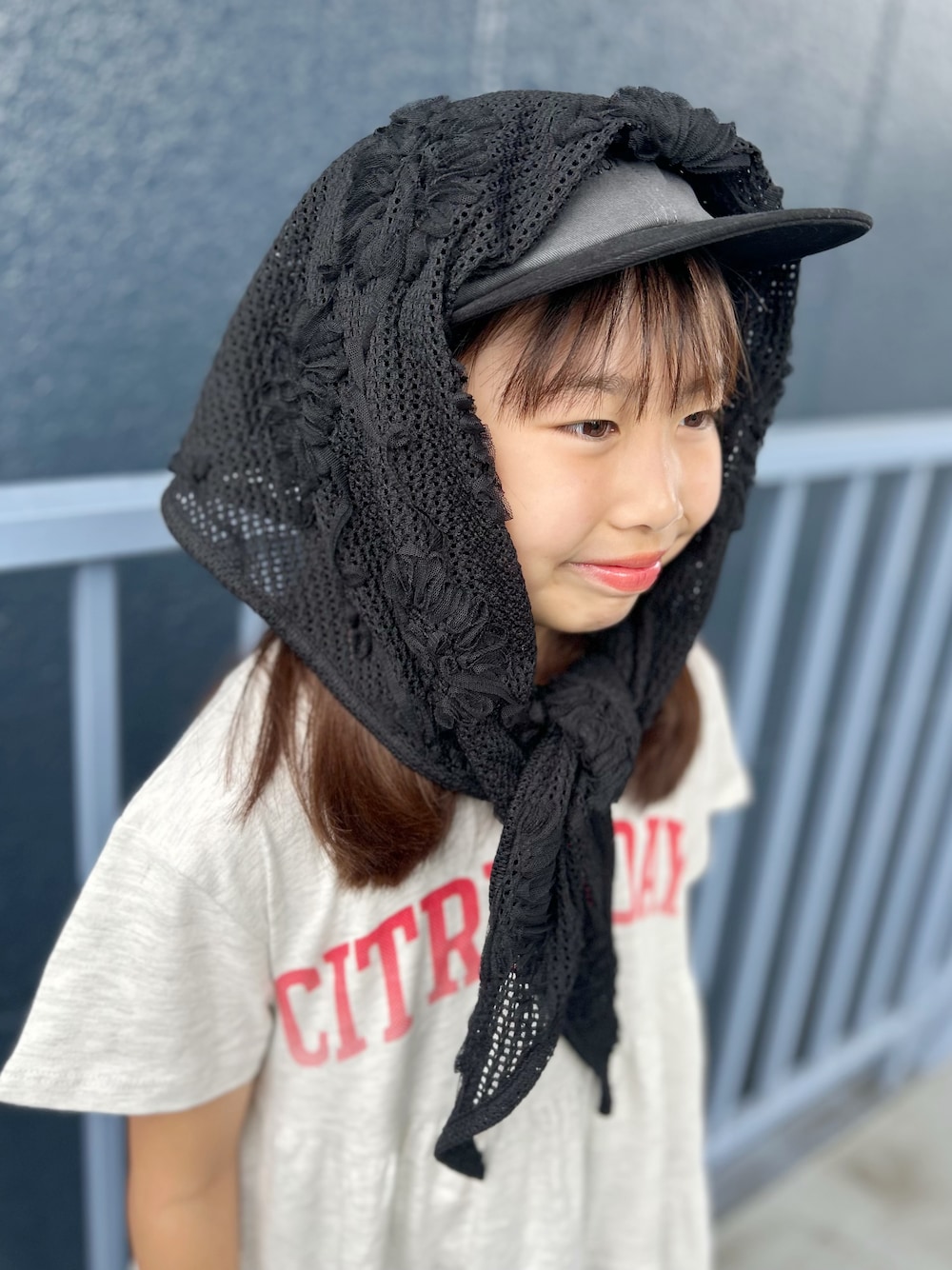 ブルー系のデニムパンツ、ホワイト系のルームワンピース、ブラック系のバンダナ/スカーフを着用したキッズの夏コーディネートの4枚目の写真