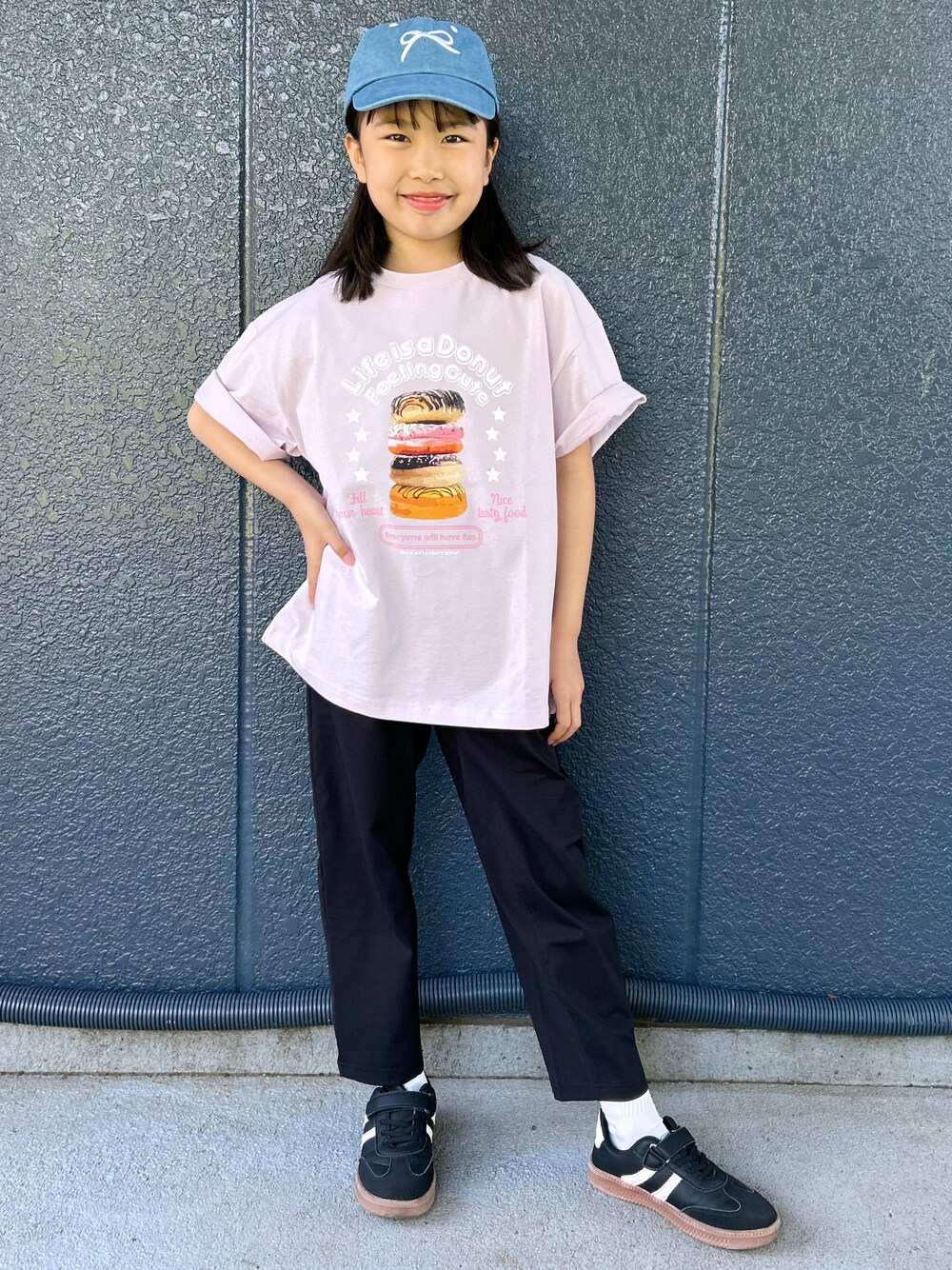 ピンク系のTシャツ/カットソー、ブラック系のその他パンツ、ブルー系のキャップを着用したレディースの春コーディネートの2枚目の写真