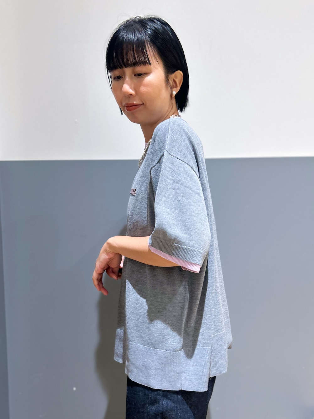 グレー系のニット/セーター、ブルー系のその他トップス、ブルー系のデニムパンツを着用したレディースの夏コーディネートの6枚目の写真