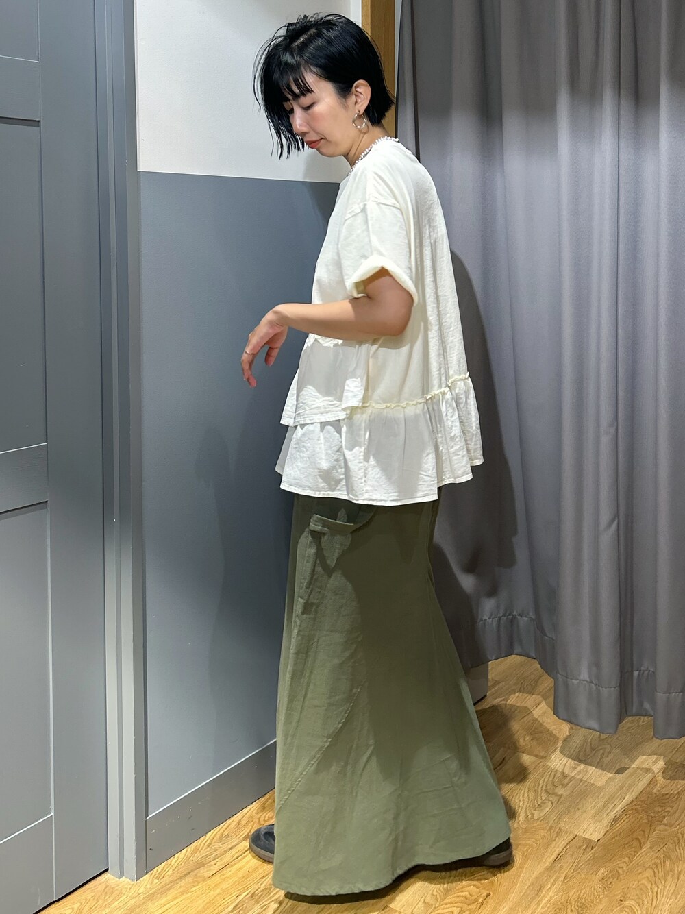 ホワイト系のTシャツ/カットソー、ブラウン系のスカート、ホワイト系のボディバッグ/ウエストポーチを着用したレディースの夏コーディネートの3枚目の写真