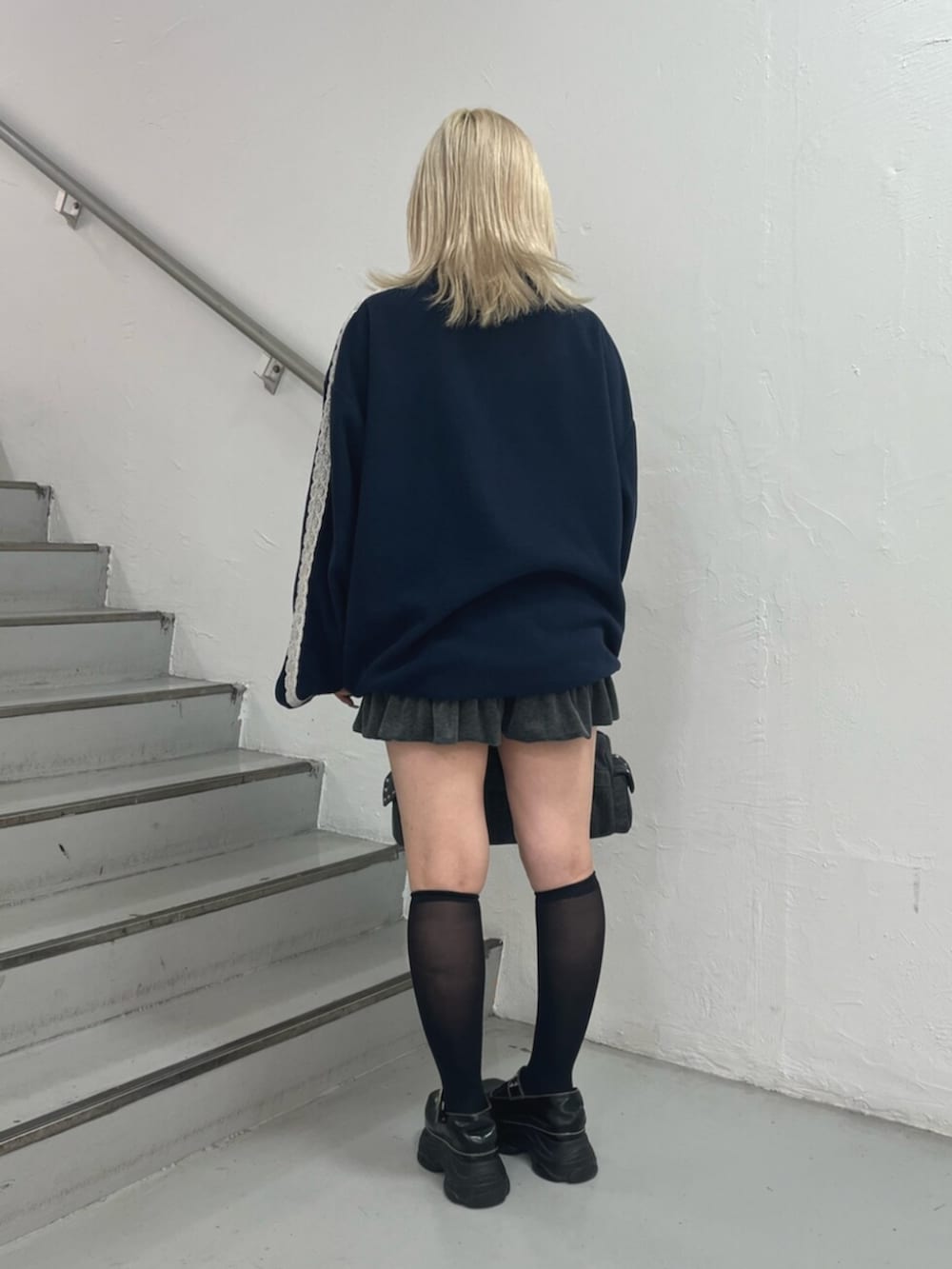 ブルー系のTシャツ/カットソー、グレー系のスカート、ブラック系のボストンバッグを着用したレディースの夏コーディネートの3枚目の写真