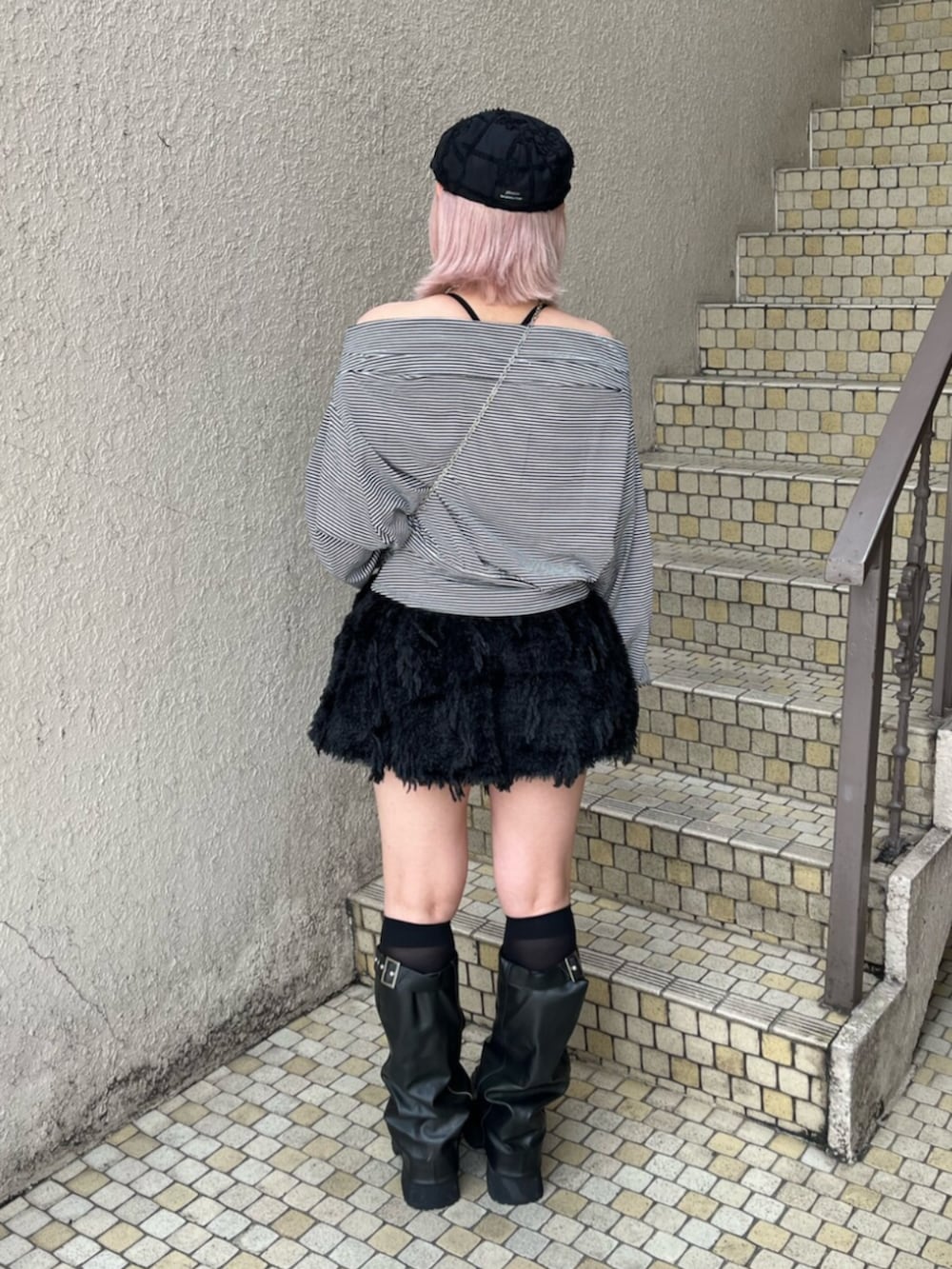 ブラック系のブーツ、ブラック系のTシャツ/カットソー、ブラック系のスカートを着用したレディースの秋コーディネートの3枚目の写真