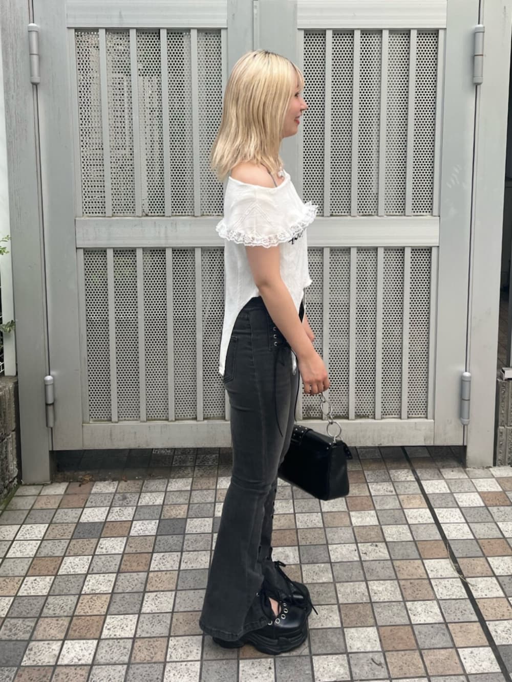 ブラック系のパンプス、ホワイト系のTシャツ/カットソー、ブラック系のデニムパンツを着用したレディースの夏コーディネートの2枚目の写真