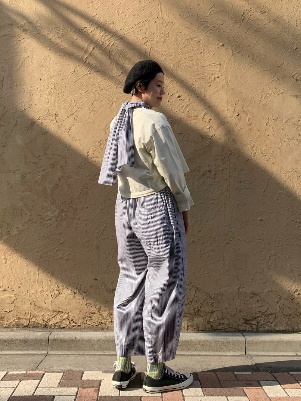 ホワイト系のトップス、ホワイト系のトップス、ブラック系のパンツを着用したレディースの春コーディネートの2枚目の写真