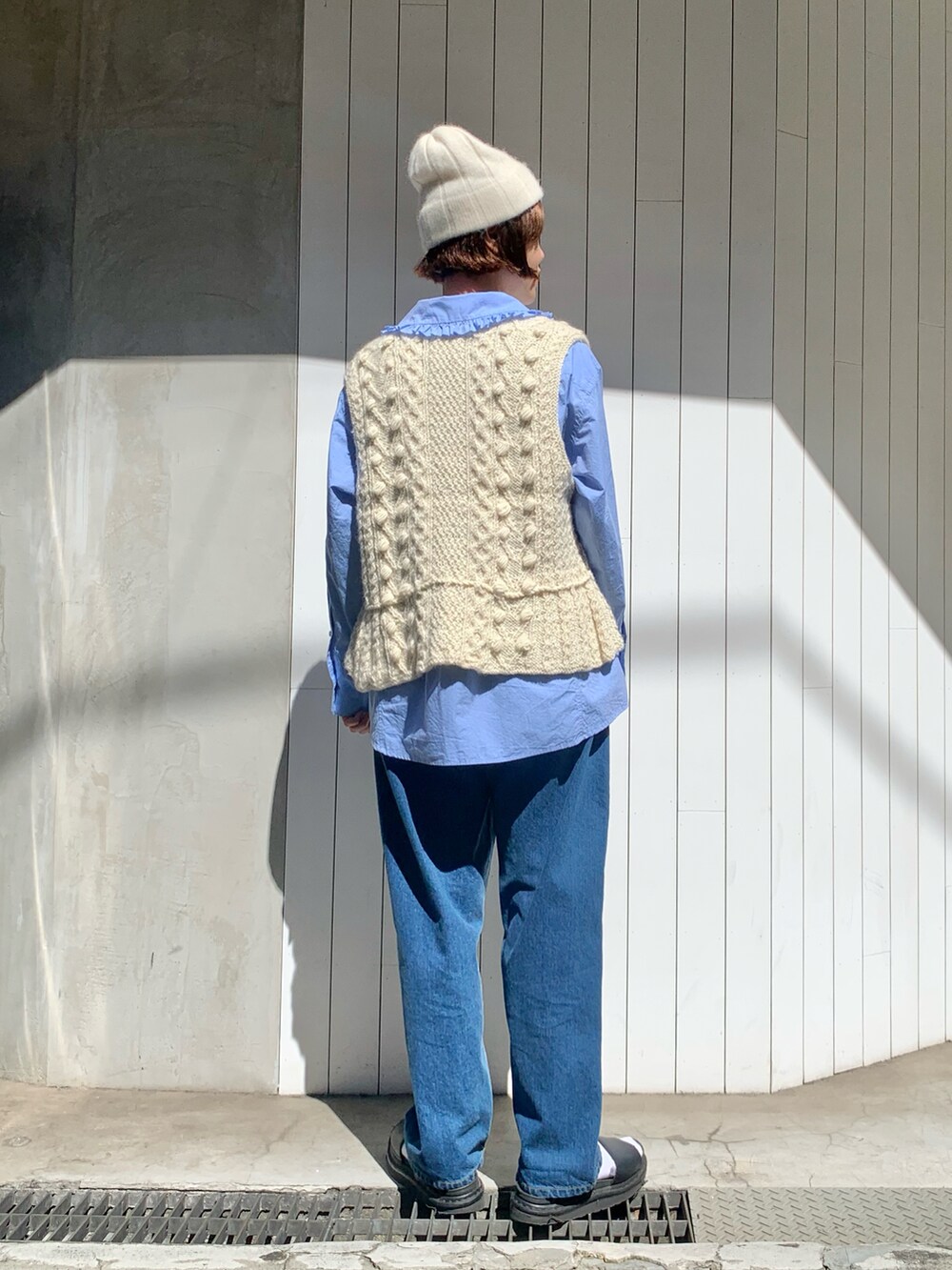 ホワイト系のベスト、ブルー系のシャツ/ブラウス、ブルー系のデニムパンツを着用したレディースの秋コーディネートの3枚目の写真