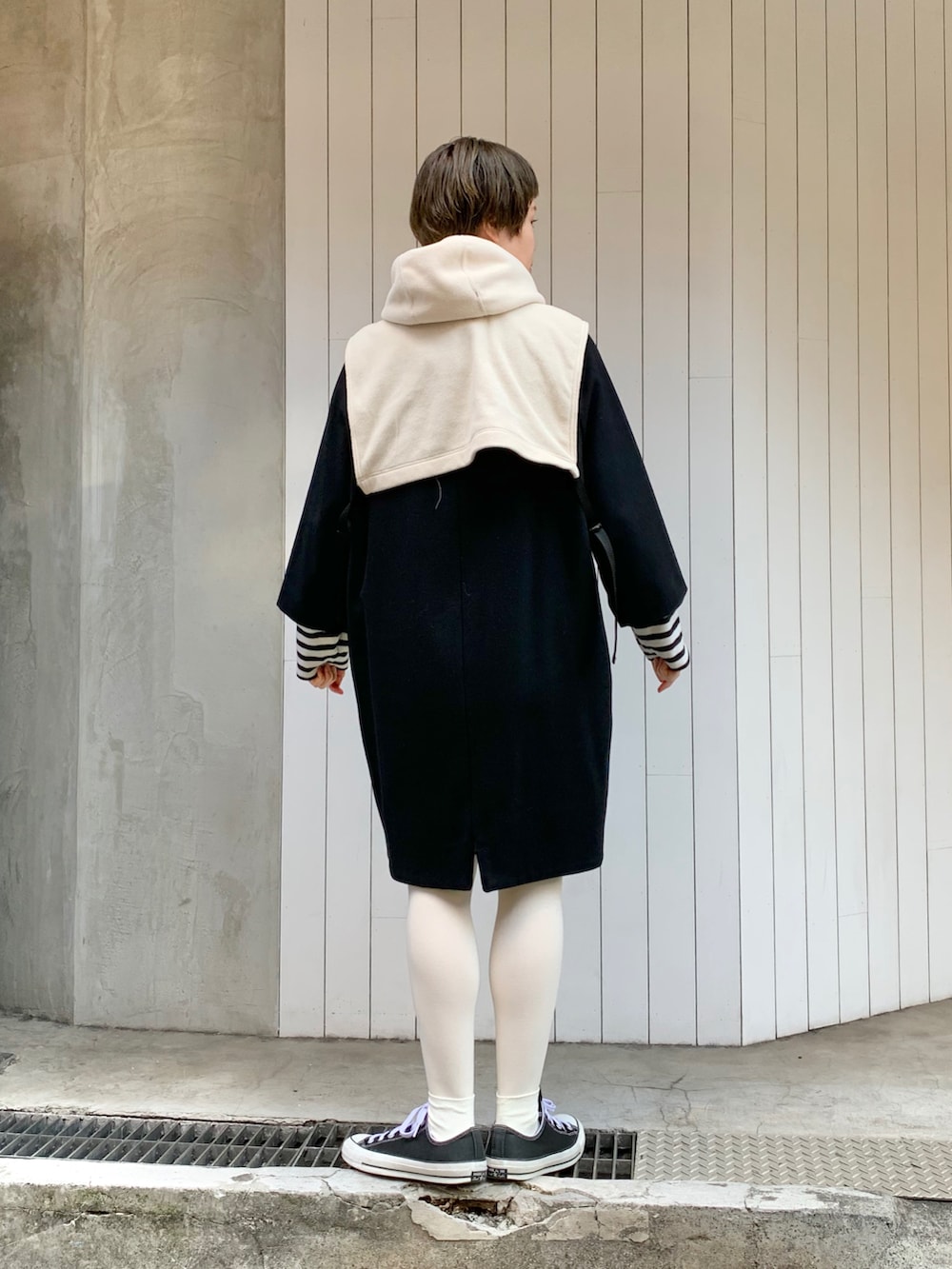 ホワイト系のベスト、ブラック系のその他アウターを着用したレディースの冬コーディネートの3枚目の写真