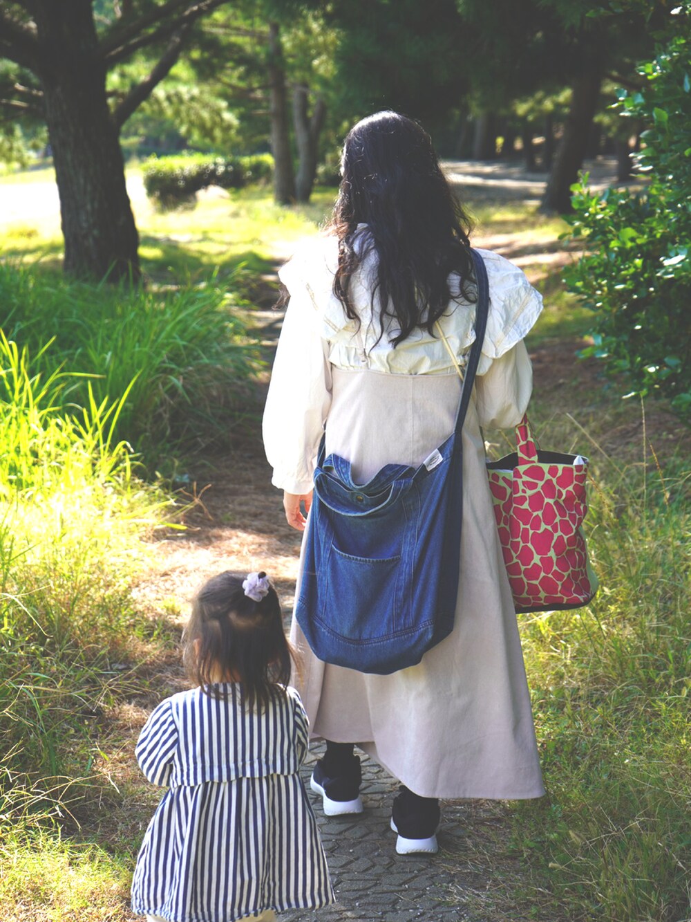 ベージュ系のワンピース、ブルー系のショルダーバッグ、ブラック系のスニーカーを着用したレディースの秋コーディネートの2枚目の写真