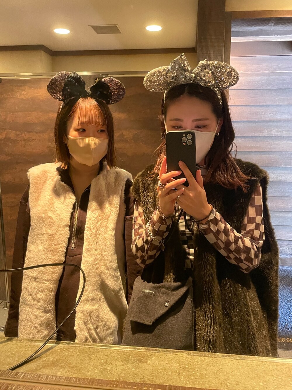 ブラウン系のベスト、ブラウン系のトップス、ブラック系のバッグを着用したレディースの秋コーディネートの2枚目の写真