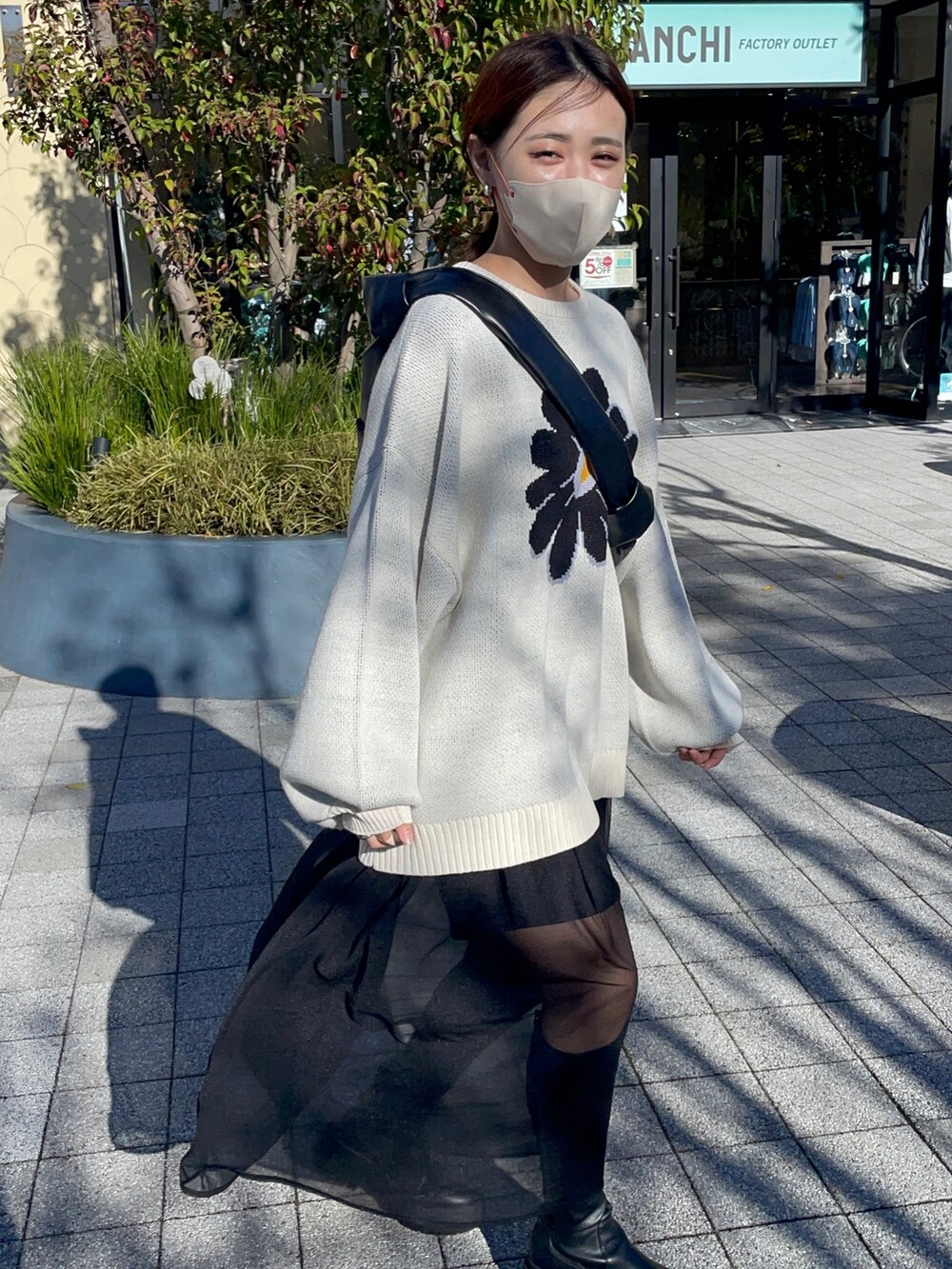 ホワイト系のニット/セーター、ブラック系のショルダーバッグを着用したレディースの冬コーディネートの2枚目の写真