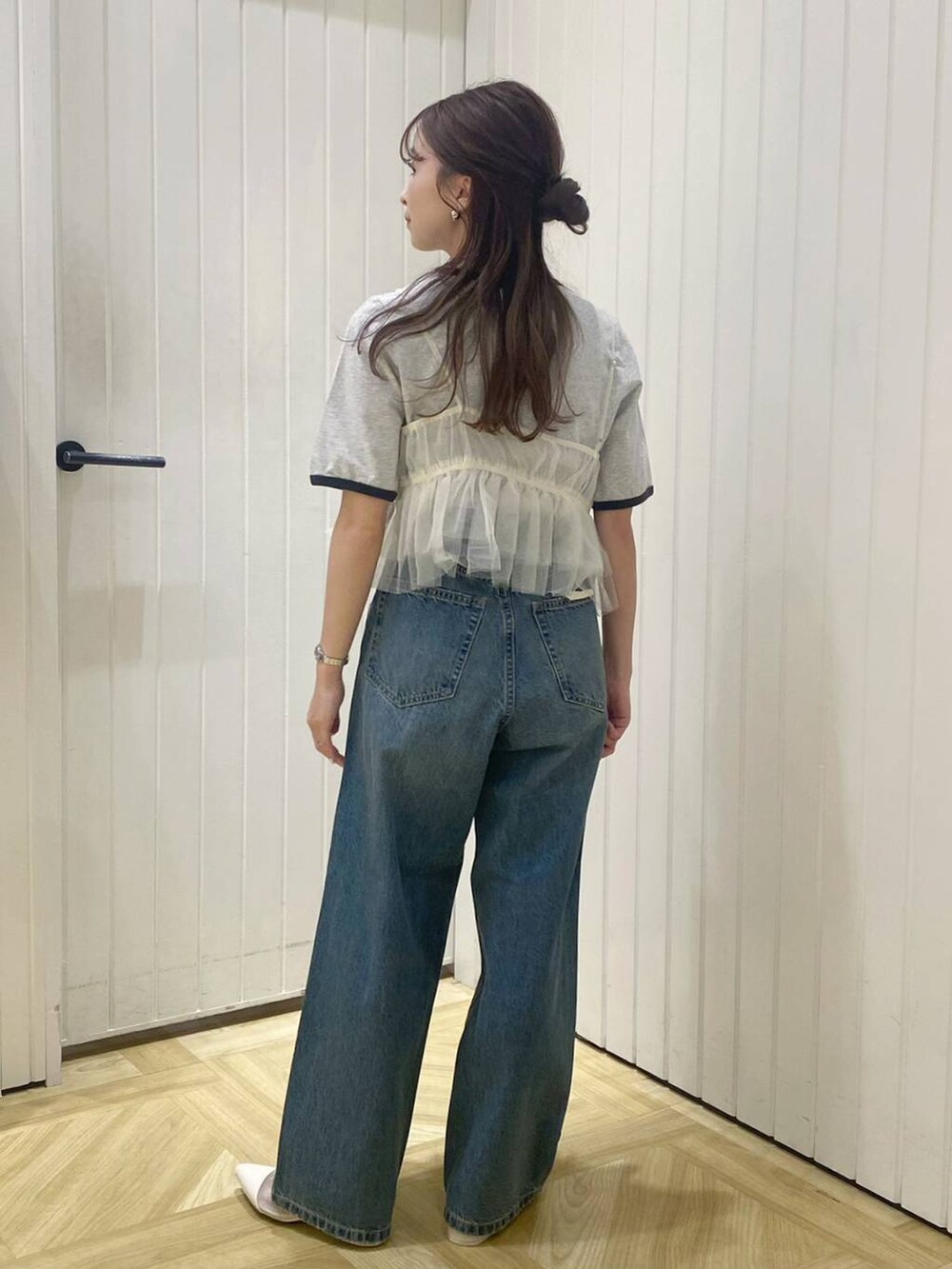 ホワイト系のブーツ、ブルー系のデニムパンツ、ホワイト系のベストを着用したレディースの春コーディネートの5枚目の写真