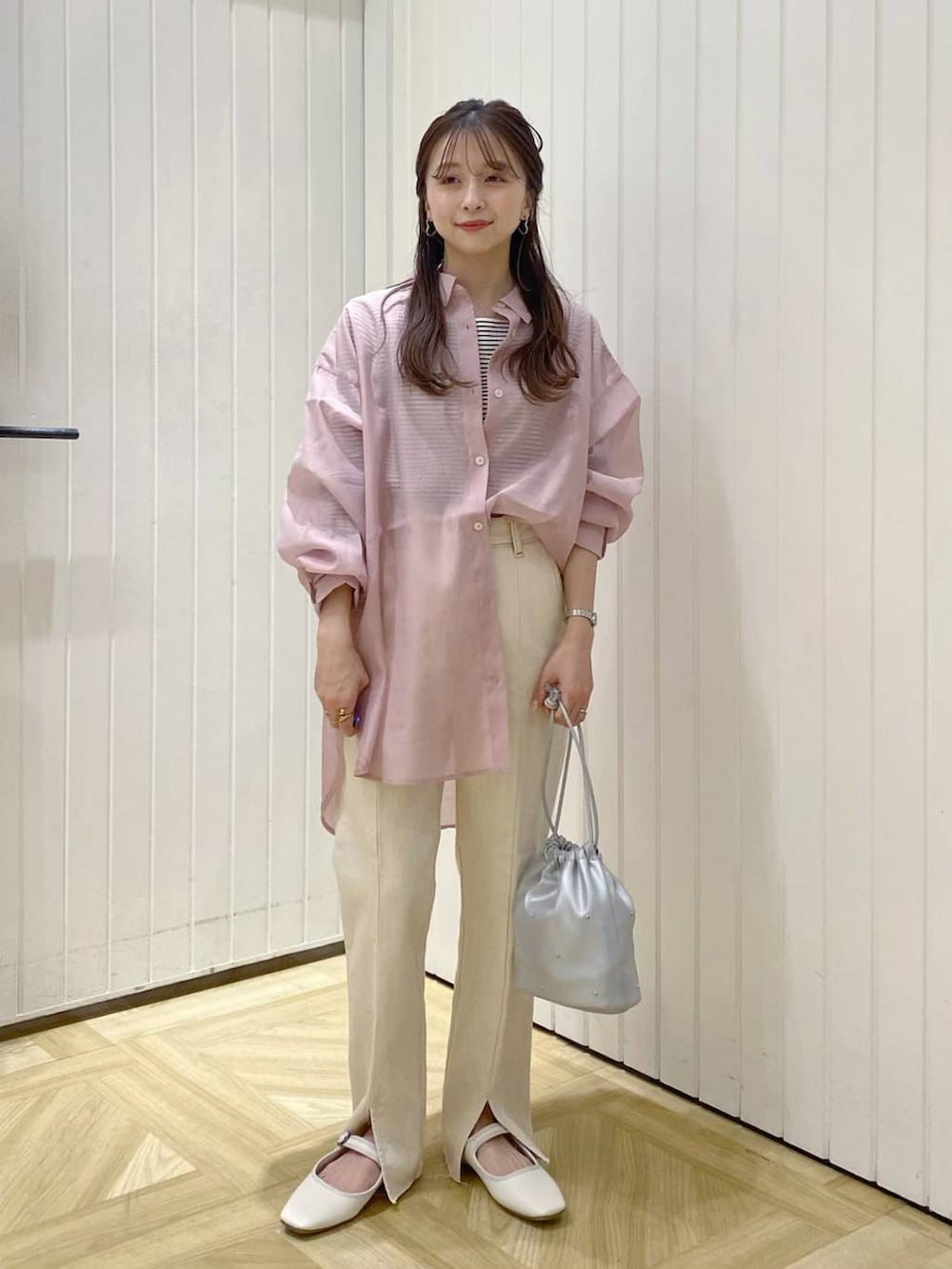 ホワイト系のデニムパンツ、シルバー系のショルダーバッグ、ホワイト系のパンプスを着用したレディースの春コーディネートの2枚目の写真