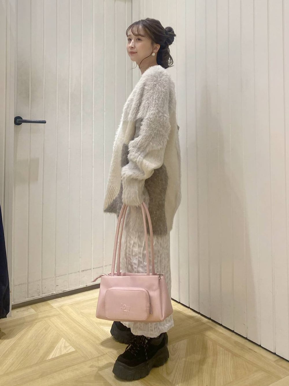 ピンク系のショルダーバッグ、ホワイト系のカーディガン/ボレロ、ホワイト系のTシャツ/カットソーを着用したレディースの秋コーディネートの2枚目の写真