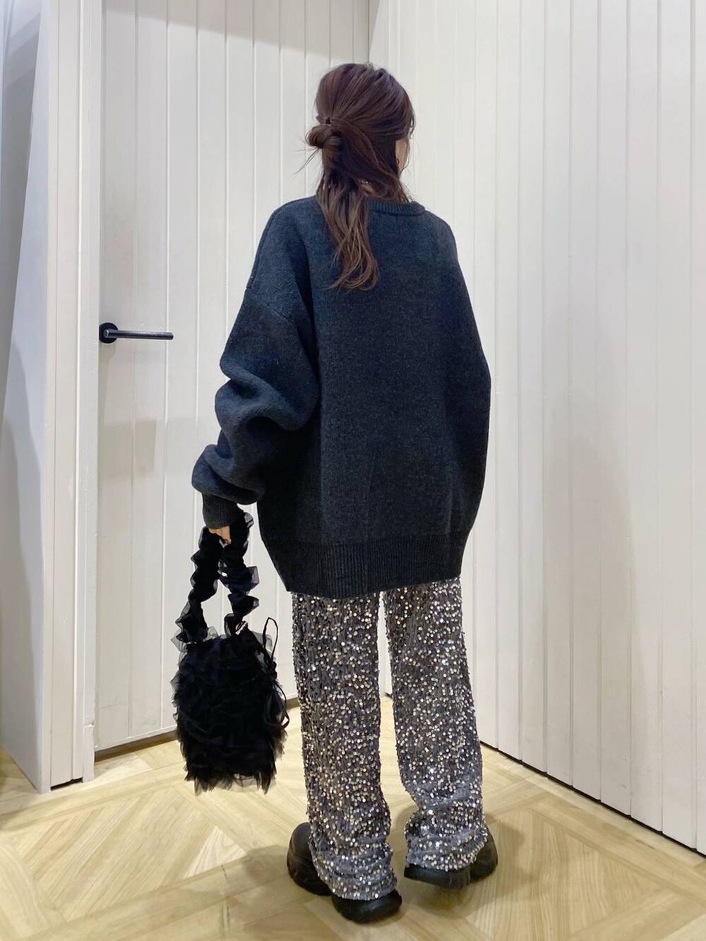 ブラック系のショルダーバッグ、ブラック系のブーツ、シルバー系のその他パンツを着用したレディースの冬コーディネートの4枚目の写真