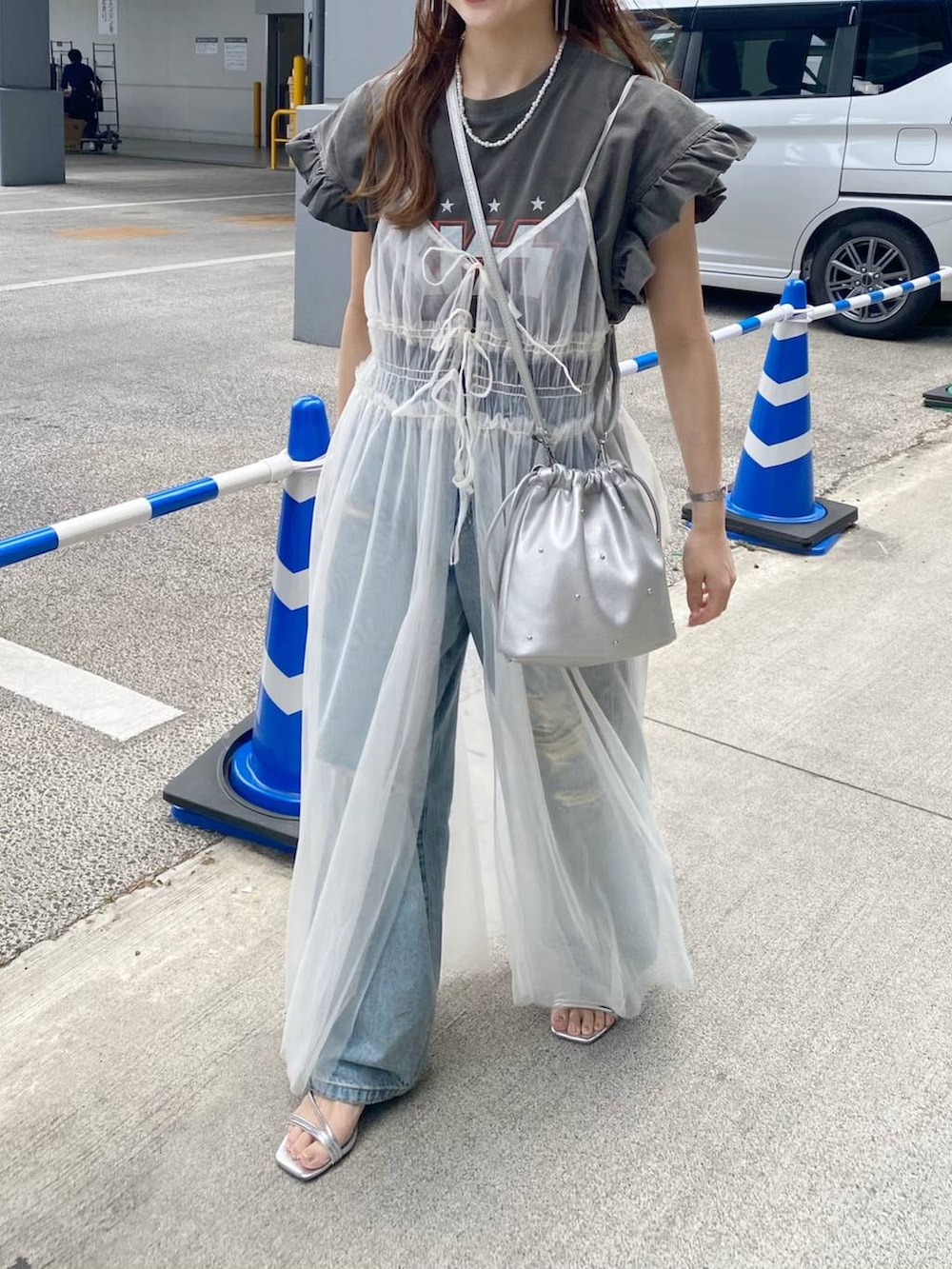 シルバー系のショルダーバッグ、シルバー系のサンダル、ベージュ系のワンピースを着用したレディースの春コーディネートの3枚目の写真