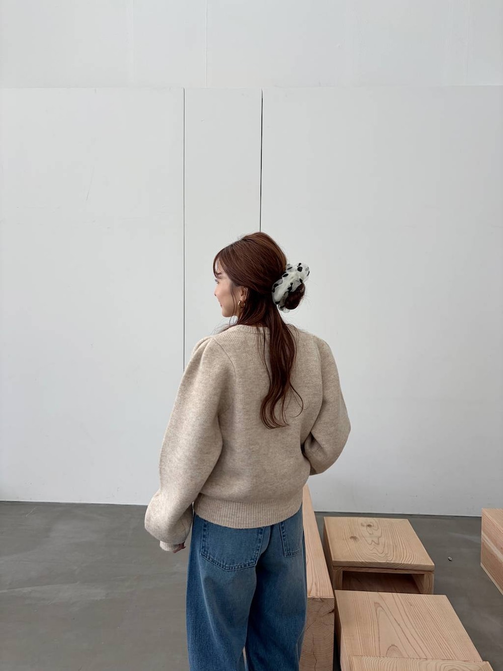 ブラウン系のブーツ、ブルー系のデニムパンツ、ホワイト系のノーカラージャケットを着用したレディースの秋コーディネートの5枚目の写真