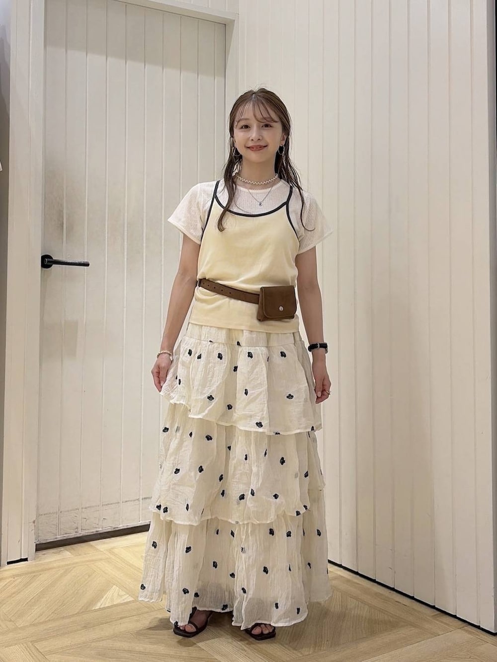 ベージュ系のTシャツ/カットソー、ブラウン系のサンダル、ホワイト系のスカートを着用したレディースの夏コーディネートの4枚目の写真