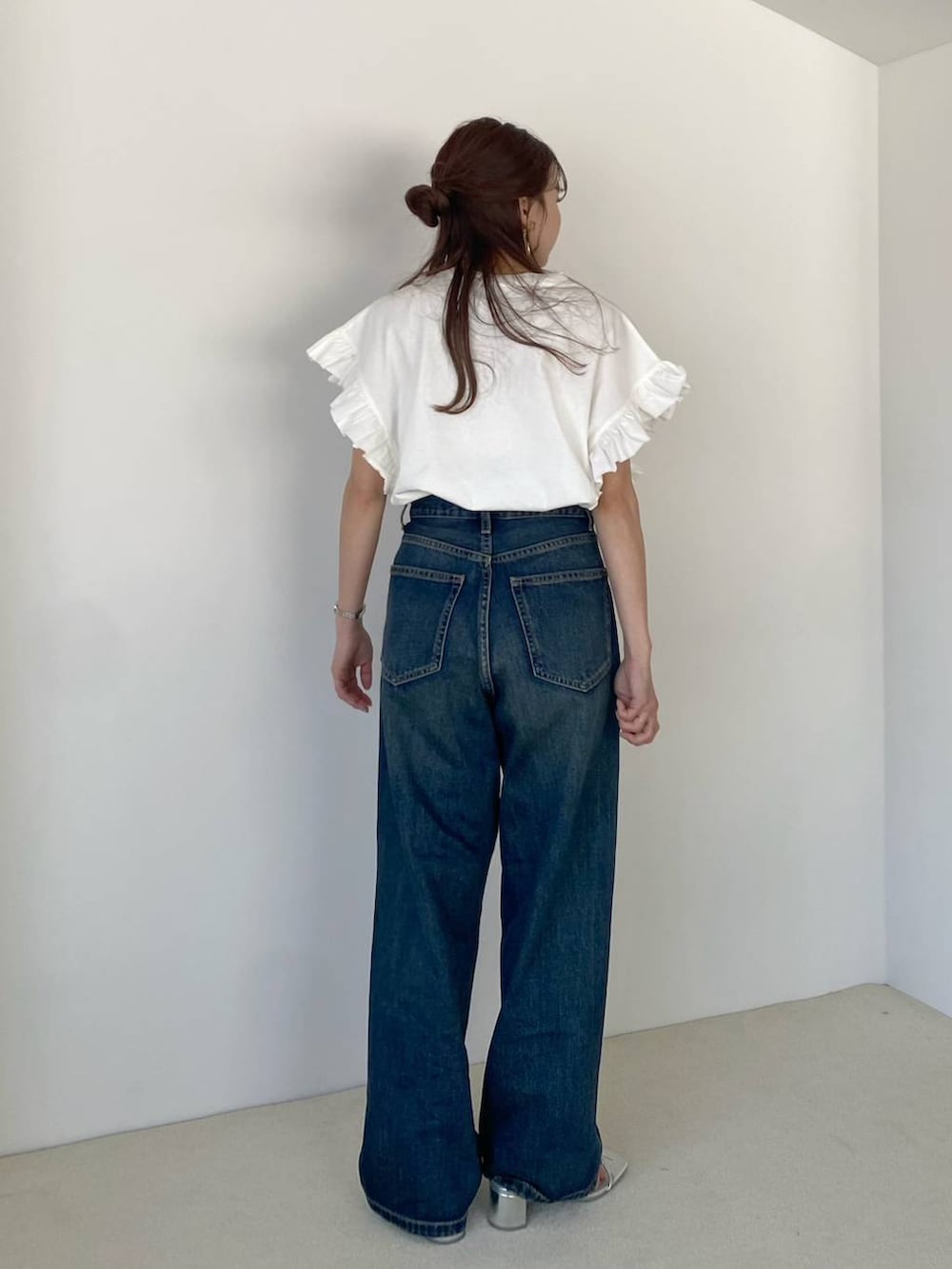 シルバー系のサンダル、ブルー系のデニムパンツ、ホワイト系のTシャツ/カットソーを着用したレディースの春コーディネートの4枚目の写真