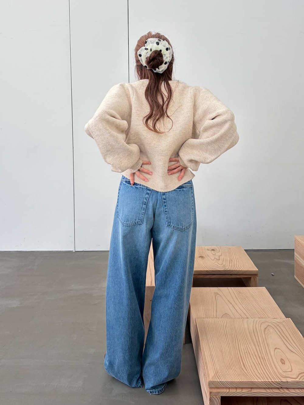 ブラウン系のブーツ、ブルー系のデニムパンツ、ホワイト系のノーカラージャケットを着用したレディースの秋コーディネートの4枚目の写真