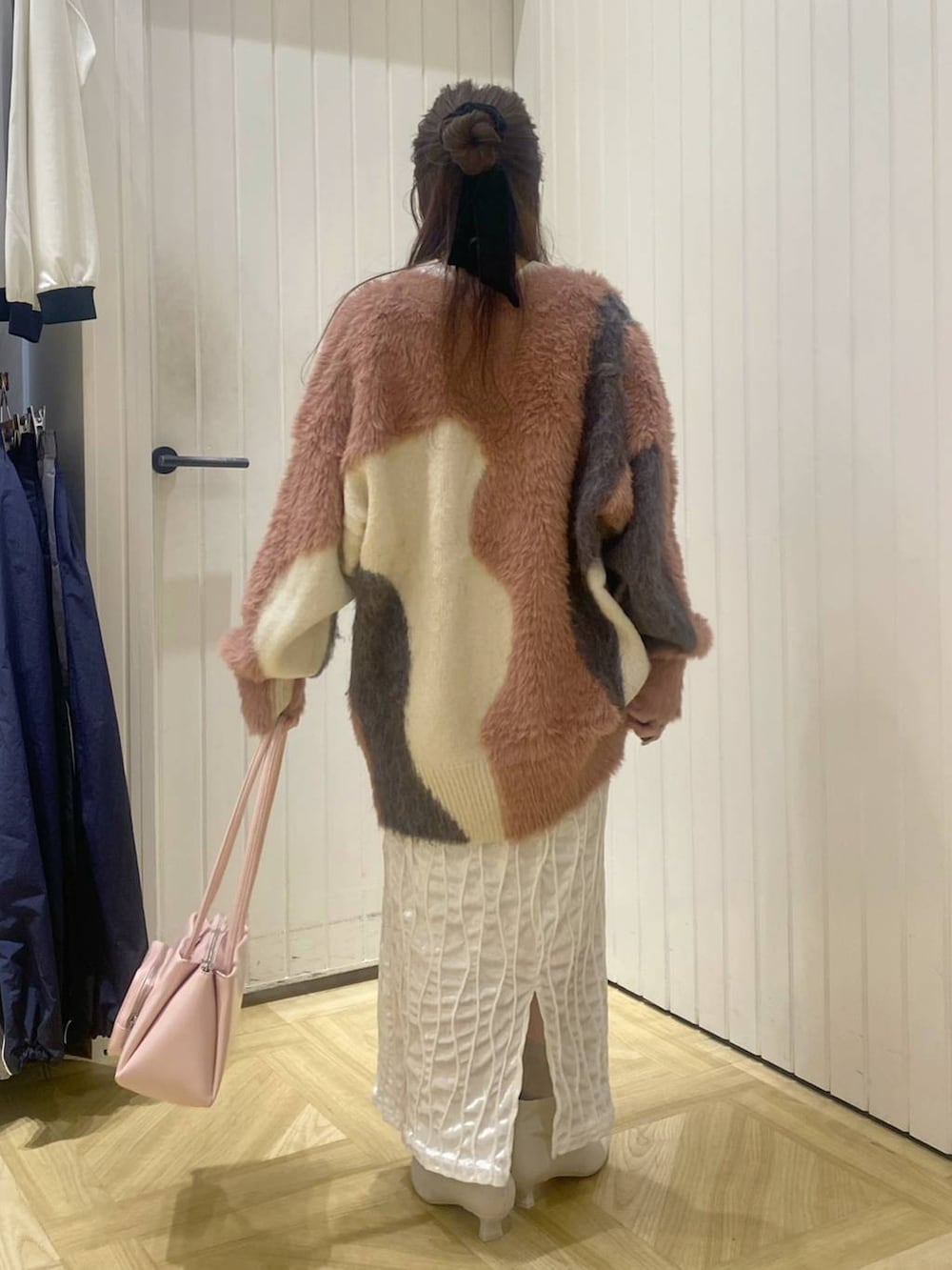 ピンク系のショルダーバッグ、ホワイト系のブーツ、ピンク系のカーディガン/ボレロを着用したレディースの秋コーディネートの3枚目の写真