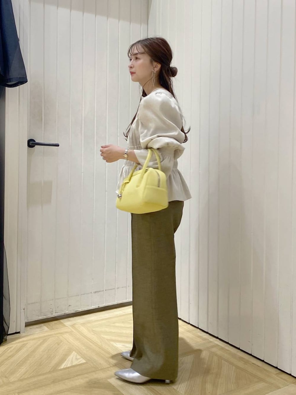 ホワイト系のシャツ/ブラウス、イエロー系のボストンバッグ、シルバー系のブーツを着用したレディースの秋コーディネートの2枚目の写真