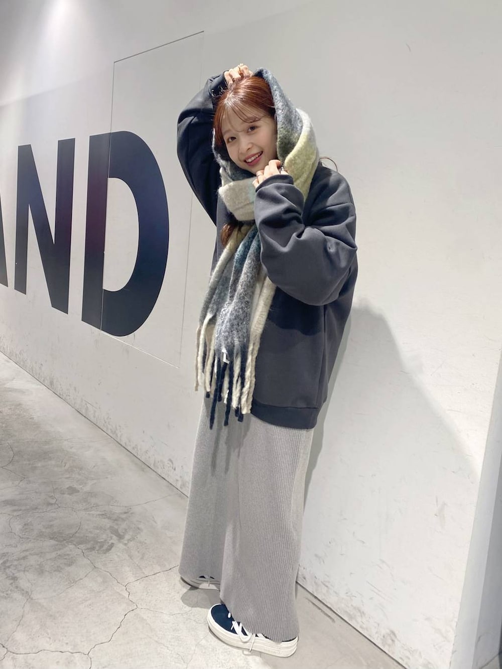 グレー系のスウェット、グレー系のマフラーを着用したレディースの冬コーディネートの2枚目の写真