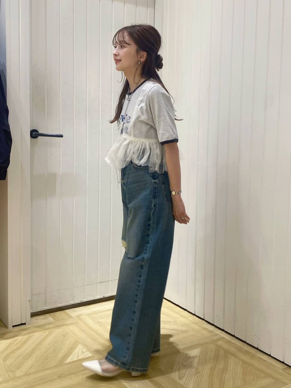 ホワイト系のブーツ、ブルー系のデニムパンツ、ホワイト系のベストを着用したレディースの春コーディネートの4枚目の写真