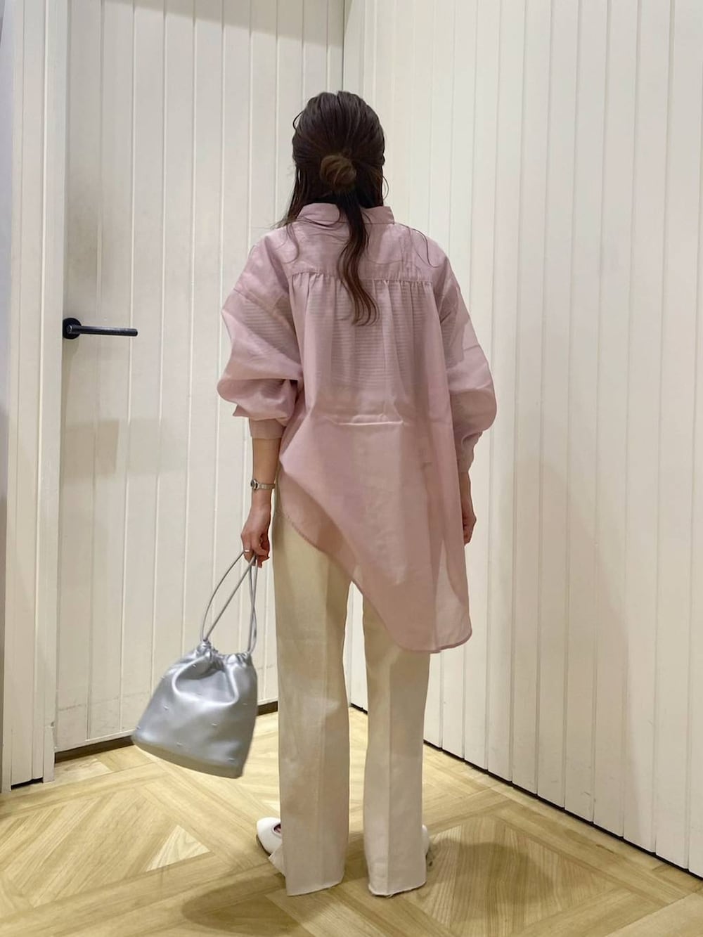 ホワイト系のデニムパンツ、シルバー系のショルダーバッグ、ホワイト系のパンプスを着用したレディースの春コーディネートの3枚目の写真