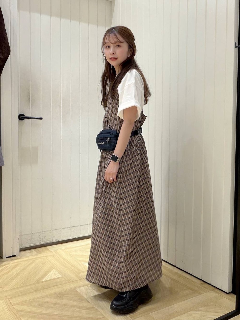 ホワイト系のTシャツ/カットソー、ブラウン系のワンピース、ブラック系のスニーカーを着用したレディースの春コーディネートの2枚目の写真