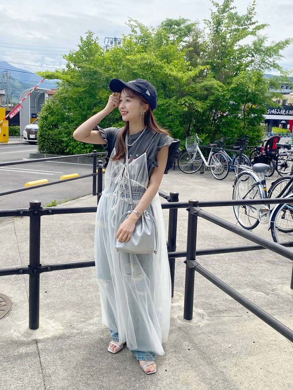 シルバー系のショルダーバッグ、シルバー系のサンダル、ベージュ系のワンピースを着用したレディースの春コーディネートの4枚目の写真