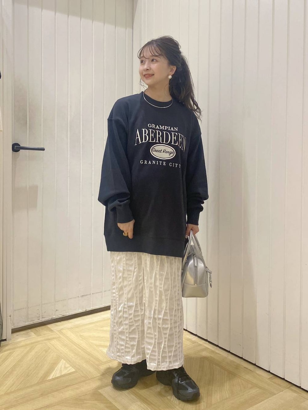 ブラック系のその他シューズ、シルバー系のボストンバッグ、グレー系のスウェットを着用したレディースの秋コーディネートの3枚目の写真