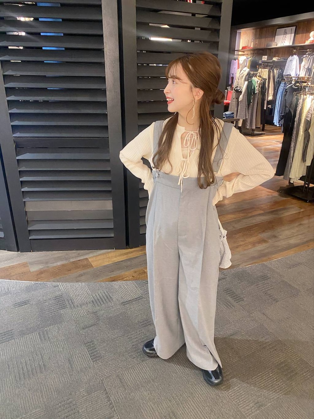 グレー系のサロペット/オーバーオール、シルバー系のショルダーバッグ、ベージュ系のニット/セーターを着用したレディースの秋コーディネートの4枚目の写真