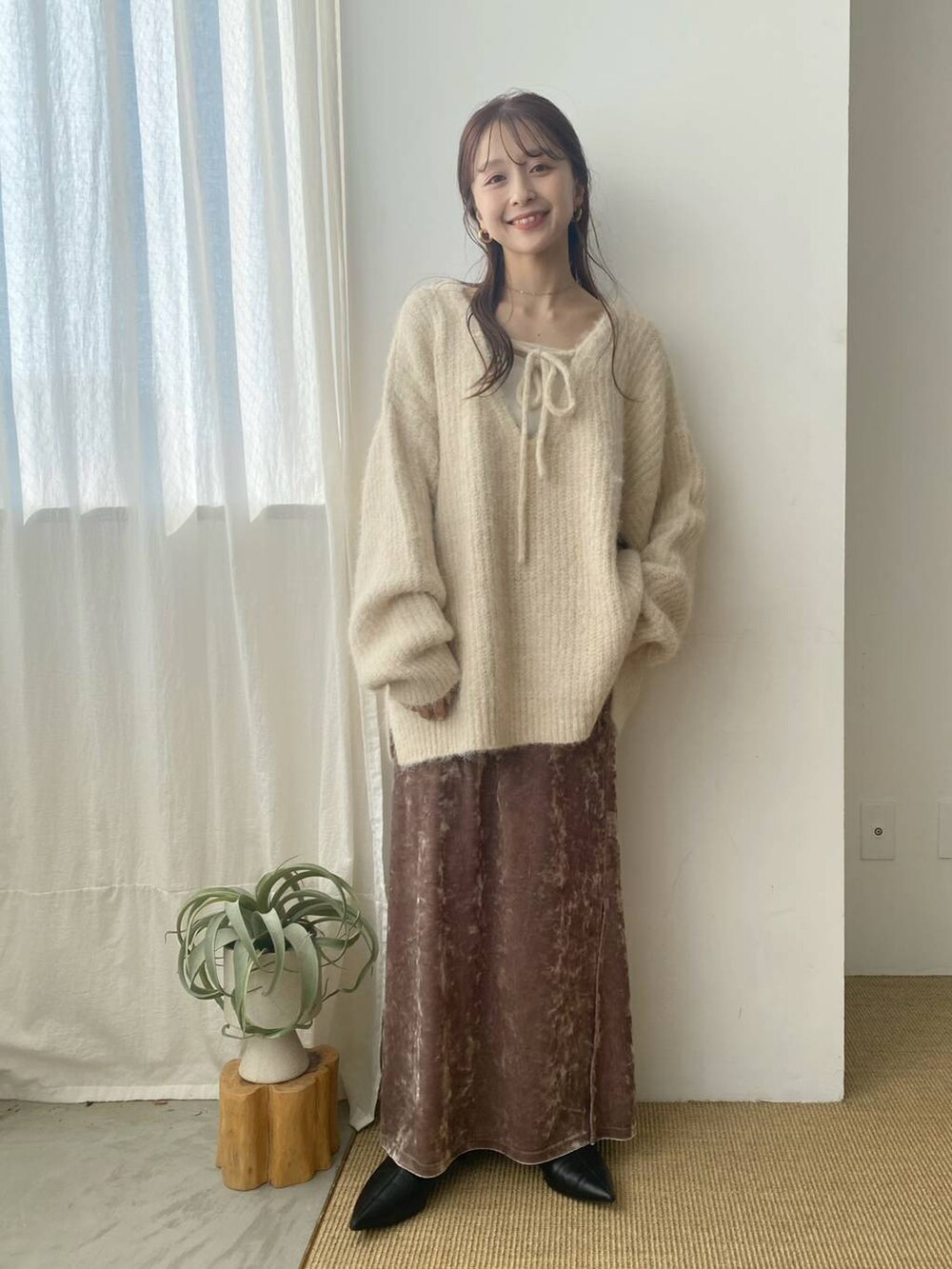 ホワイト系のキャミソール、ホワイト系のニット/セーター、ピンク系のスカートを着用したレディースの秋コーディネートの4枚目の写真