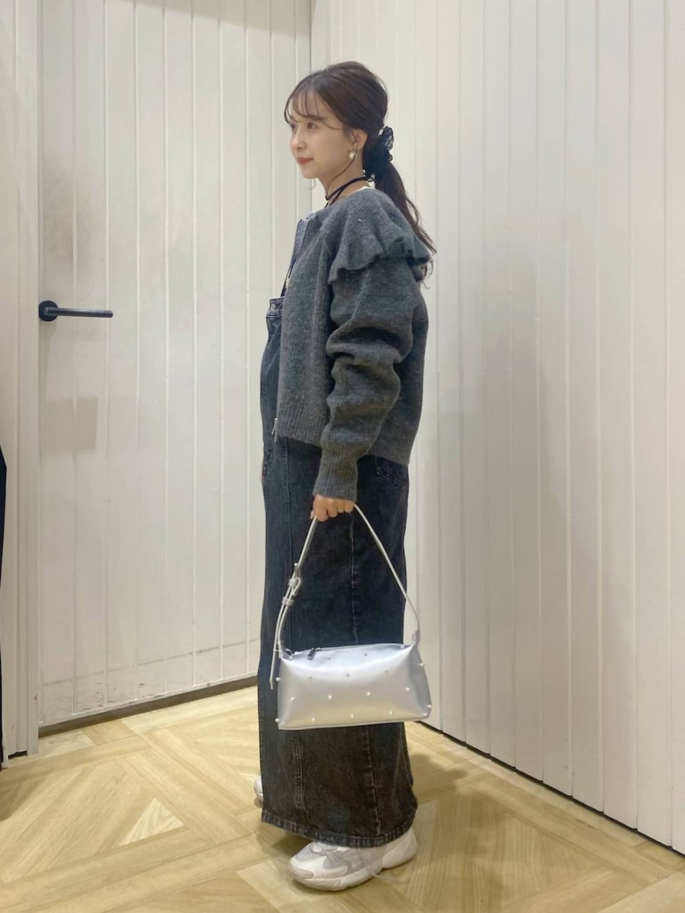 ブラック系のジャンパースカート、ホワイト系のカーディガン/ボレロ、ホワイト系のTシャツ/カットソーを着用したレディースの秋コーディネートの2枚目の写真