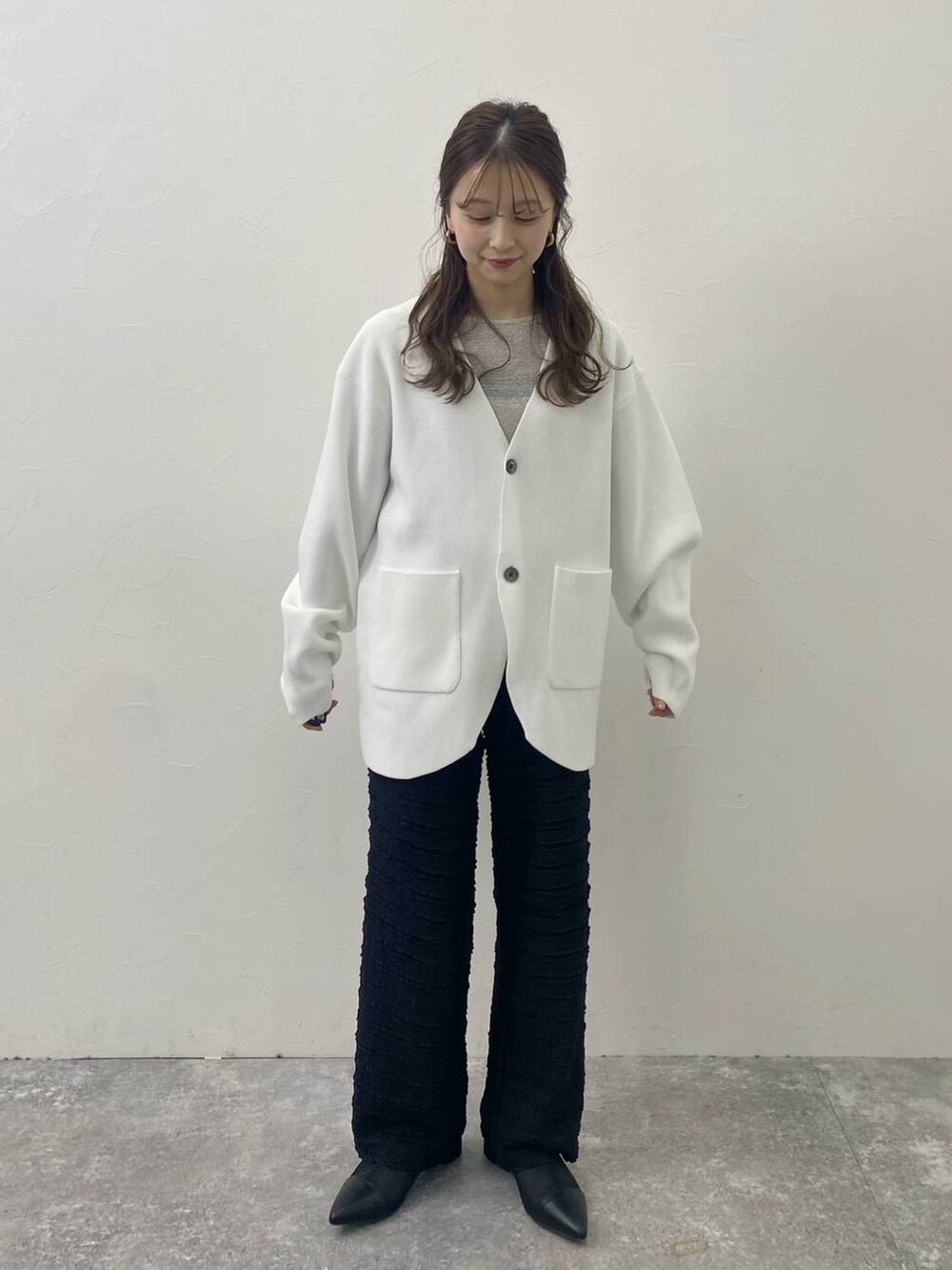ブラック系のその他パンツ、グレー系のTシャツ/カットソー、ホワイト系のカーディガン/ボレロを着用したレディースの冬コーディネートの2枚目の写真