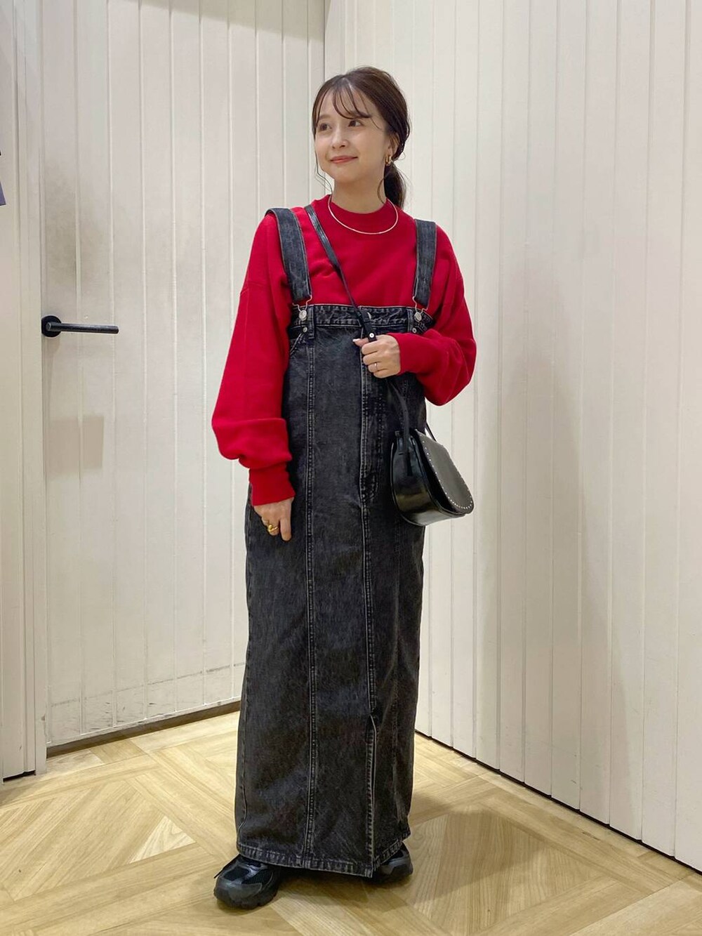 ブラック系のその他シューズ、ブラック系のジャンパースカート、レッド系のニット/セーターを着用したレディースの秋コーディネートの2枚目の写真