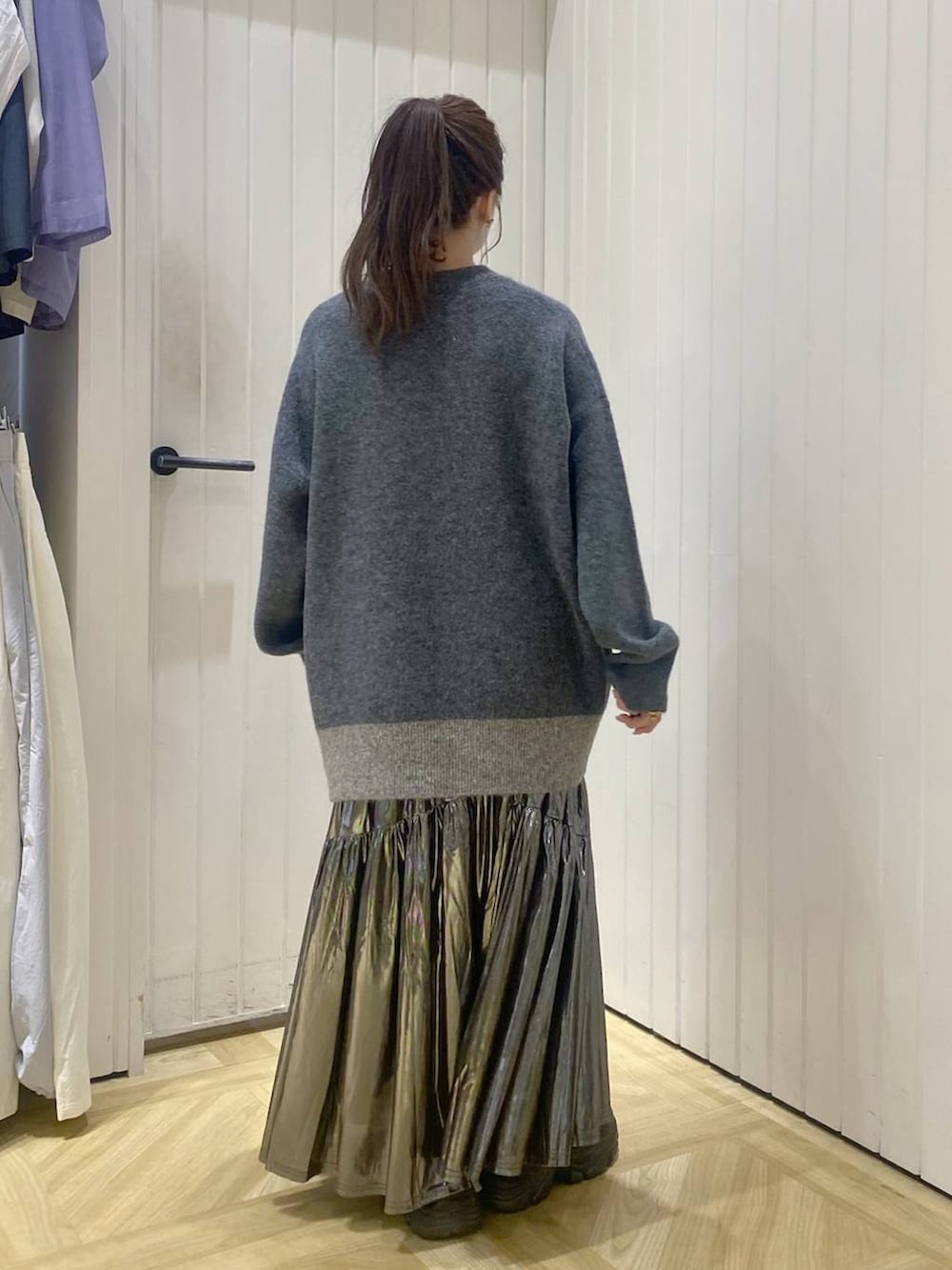 ブラック系のブーツ、ホワイト系のスカート、グレー系のニット/セーターを着用したレディースの秋コーディネートの3枚目の写真