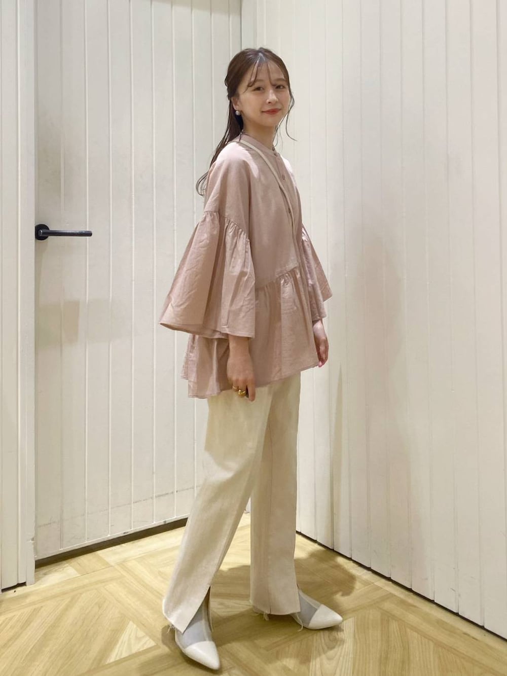 ベージュ系のショルダーバッグ、ホワイト系のブーツ、ピンク系のシャツ/ブラウスを着用したレディースの春コーディネートの3枚目の写真