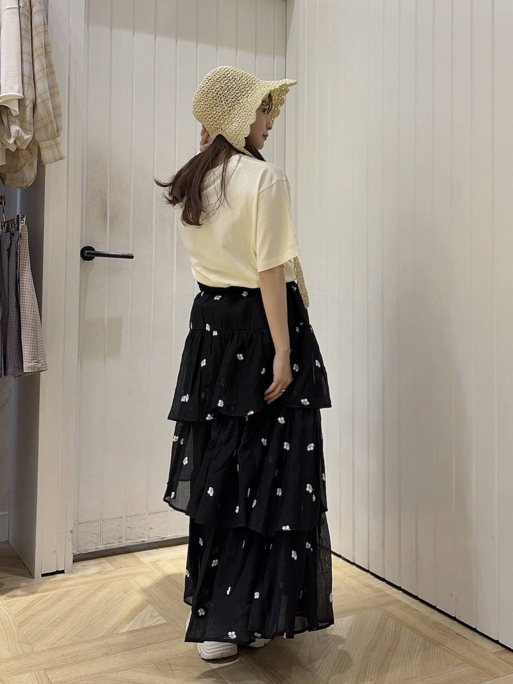 ベージュ系のTシャツ/カットソー、ブラック系のスカート、ホワイト系のスニーカーを着用したレディースの夏コーディネートの3枚目の写真