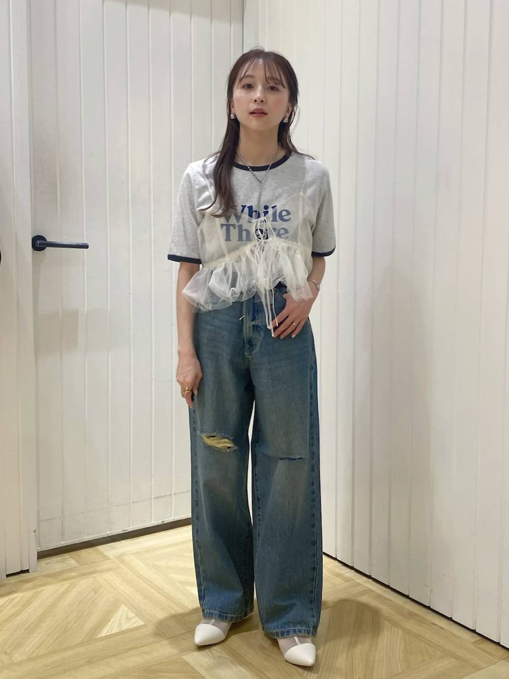 ホワイト系のブーツ、ブルー系のデニムパンツ、ホワイト系のベストを着用したレディースの春コーディネートの2枚目の写真