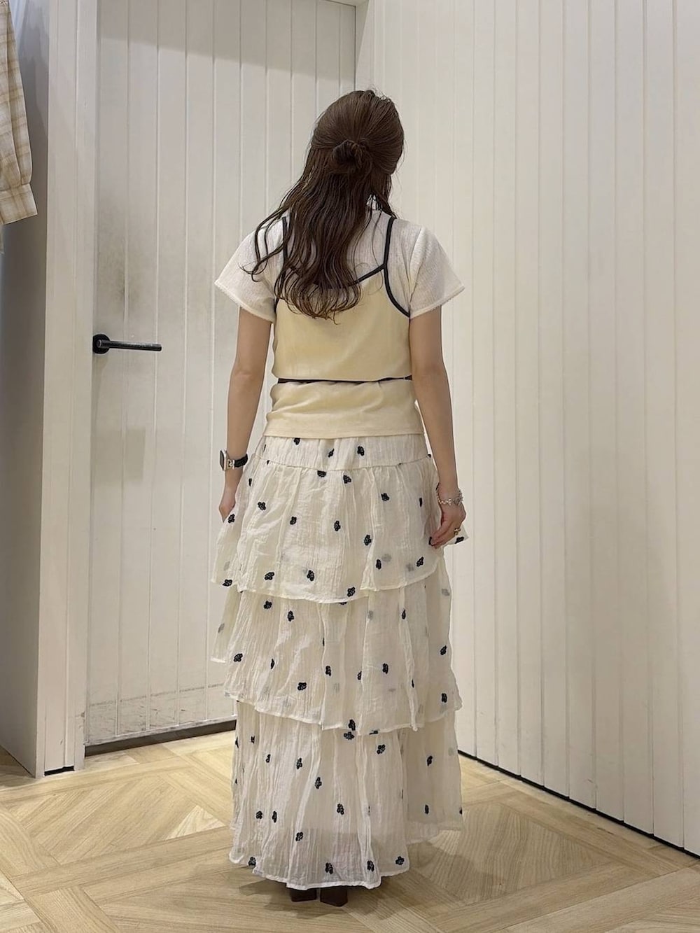ベージュ系のTシャツ/カットソー、ブラウン系のサンダル、ホワイト系のスカートを着用したレディースの夏コーディネートの3枚目の写真