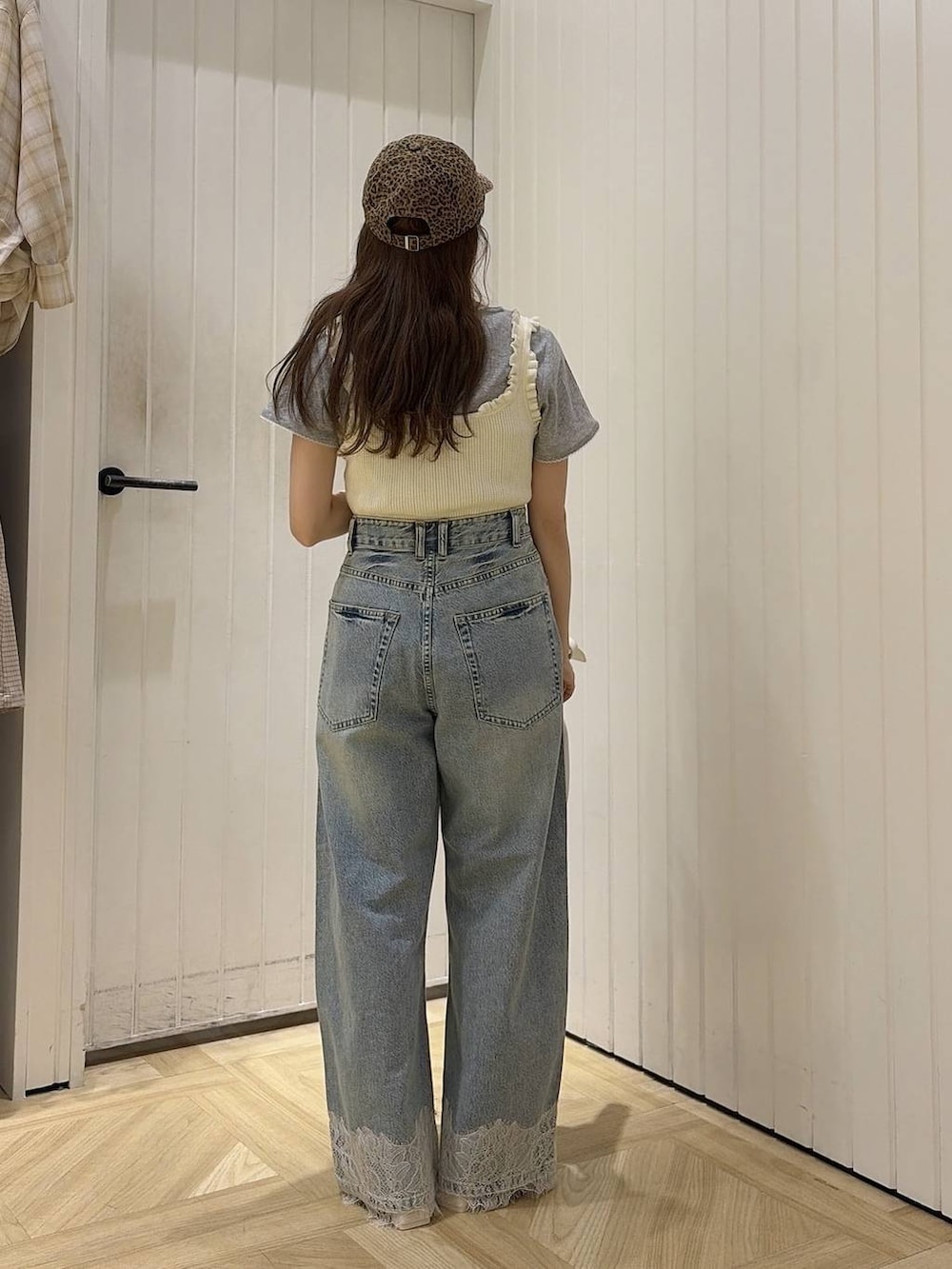 ブルー系のデニムパンツ、ホワイト系のタンクトップ、ホワイト系のショルダーバッグを着用したレディースの春コーディネートの3枚目の写真