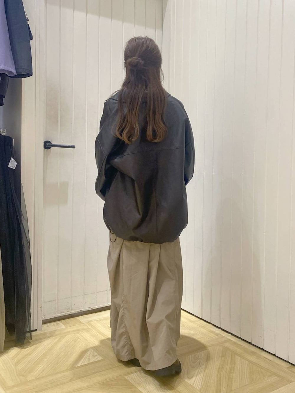 ブラウン系のブルゾン、ブラック系のボストンバッグ、ホワイト系のワンピースを着用したレディースの秋コーディネートの3枚目の写真