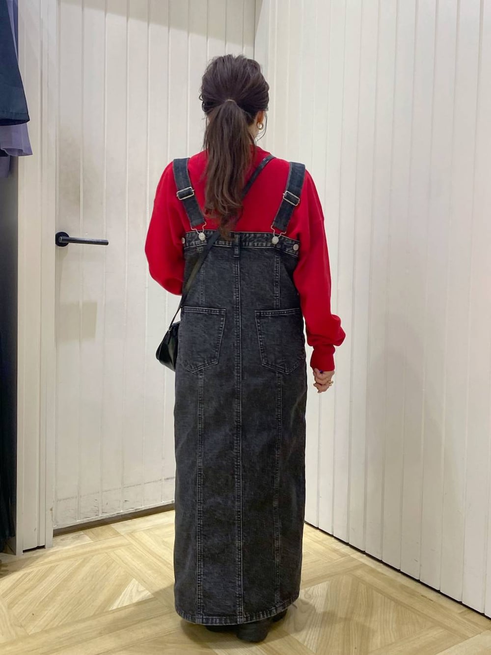 ブラック系のその他シューズ、ブラック系のジャンパースカート、レッド系のニット/セーターを着用したレディースの秋コーディネートの4枚目の写真