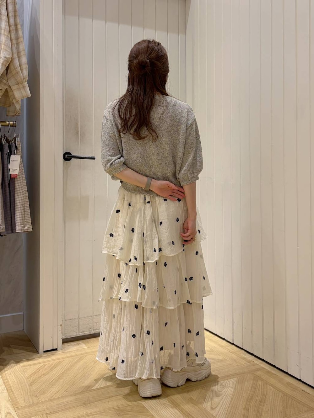 ホワイト系のスカート、グレー系のTシャツ/カットソー、ホワイト系のスニーカーを着用したレディースの春コーディネートの3枚目の写真