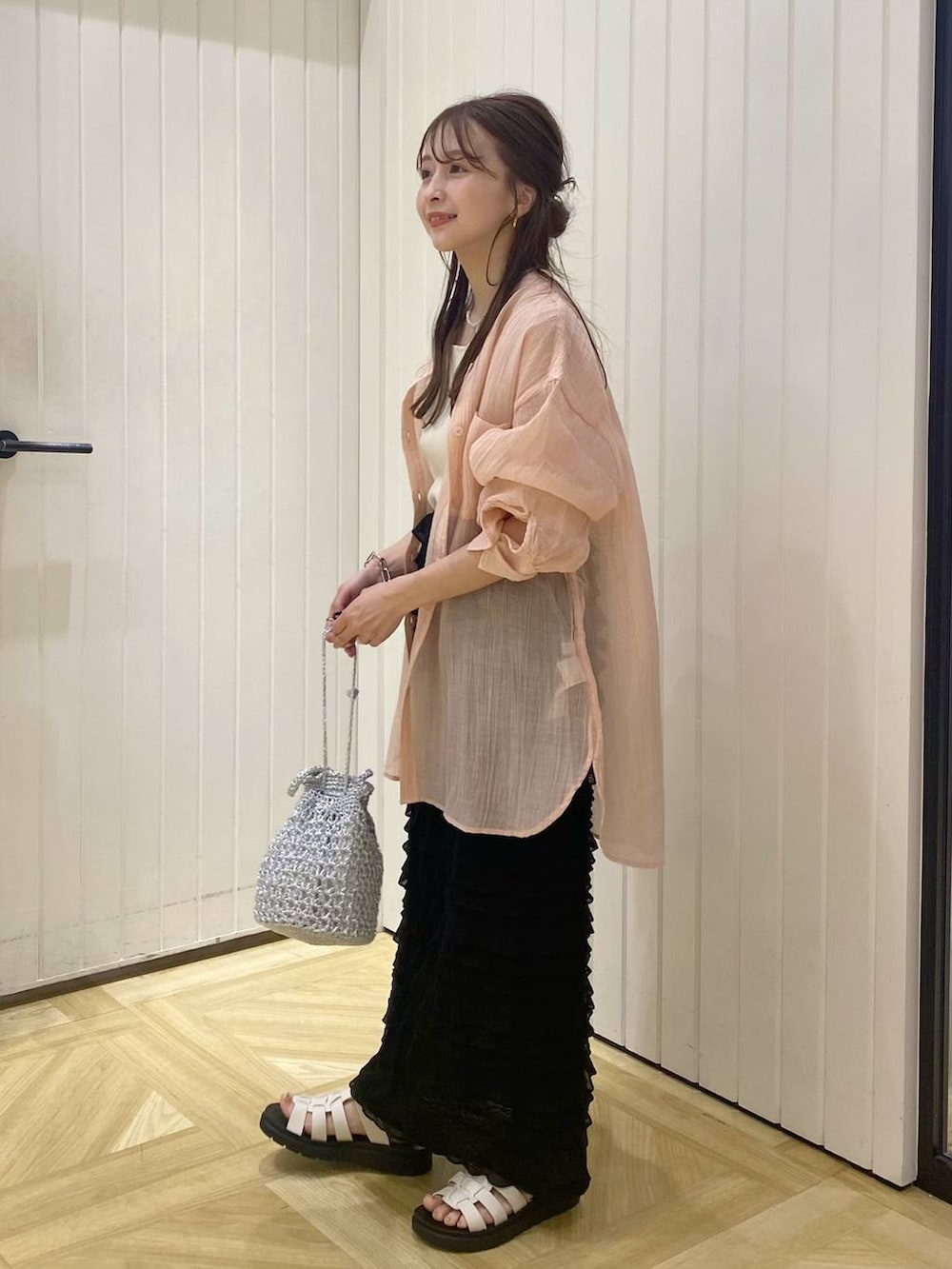 ホワイト系のTシャツ/カットソー、ブラック系のスカート、ホワイト系のスニーカーを着用したレディースの春コーディネートの2枚目の写真