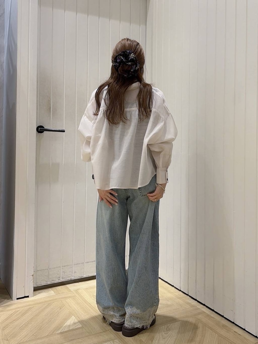 ブルー系のデニムパンツ、ホワイト系のシャツ/ブラウス、ホワイト系のサンダルを着用したレディースの夏コーディネートの3枚目の写真