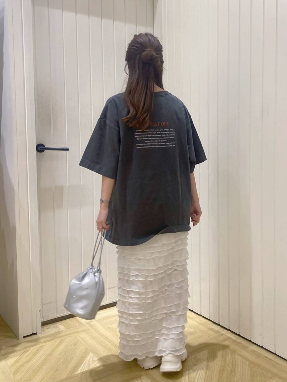 ホワイト系のサンダル、ホワイト系のスカート、シルバー系のショルダーバッグを着用したレディースの春コーディネートの3枚目の写真