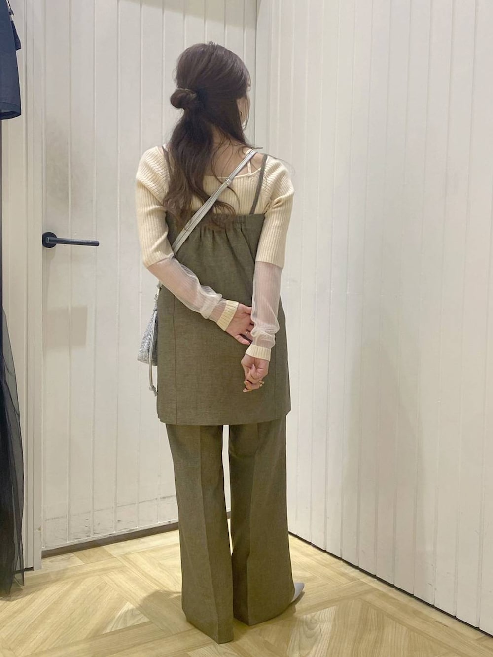 ブラウン系のスラックス、シルバー系のショルダーバッグ、シルバー系のブーツを着用したレディースの秋コーディネートの4枚目の写真