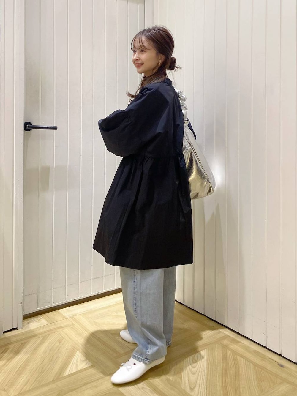 グレー系のトートバッグ、ブラック系のワンピース、ブルー系のデニムパンツを着用したレディースの春コーディネートの2枚目の写真